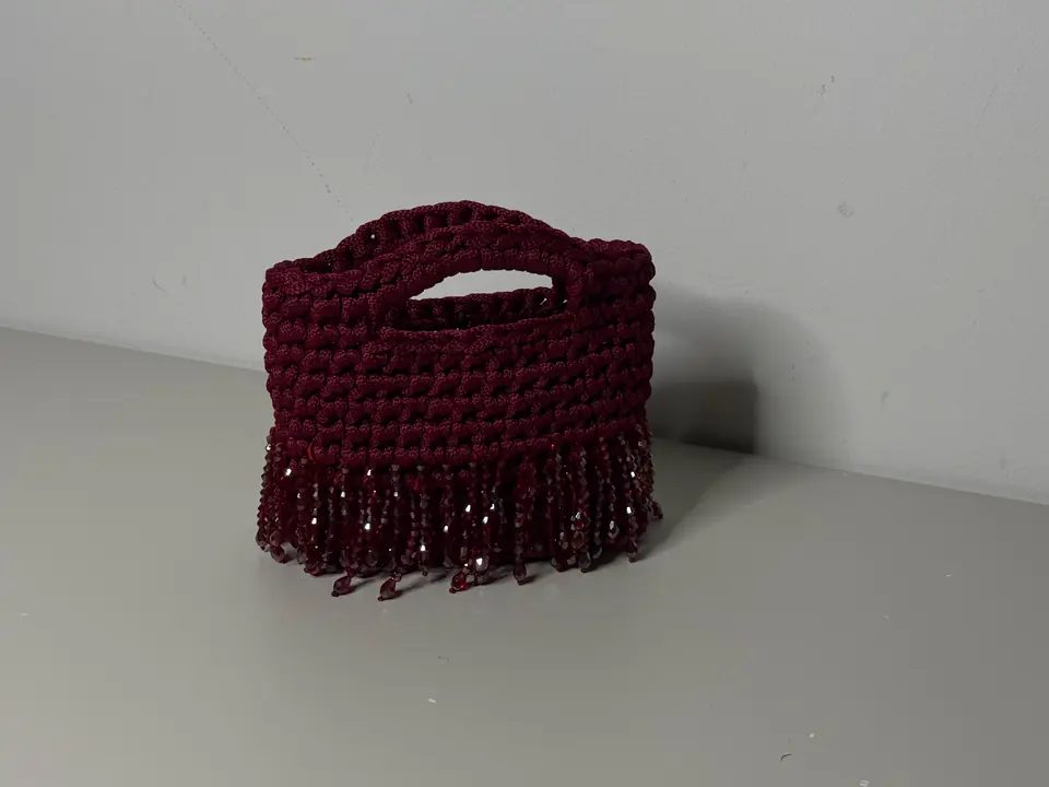 Borsa crochet bordeaux in una fotografia editoriale