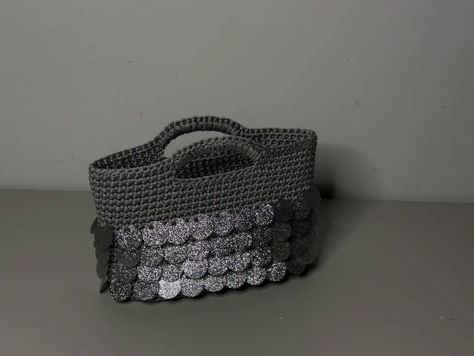 Borsa crochet grigio argento in una fotografia editoriale